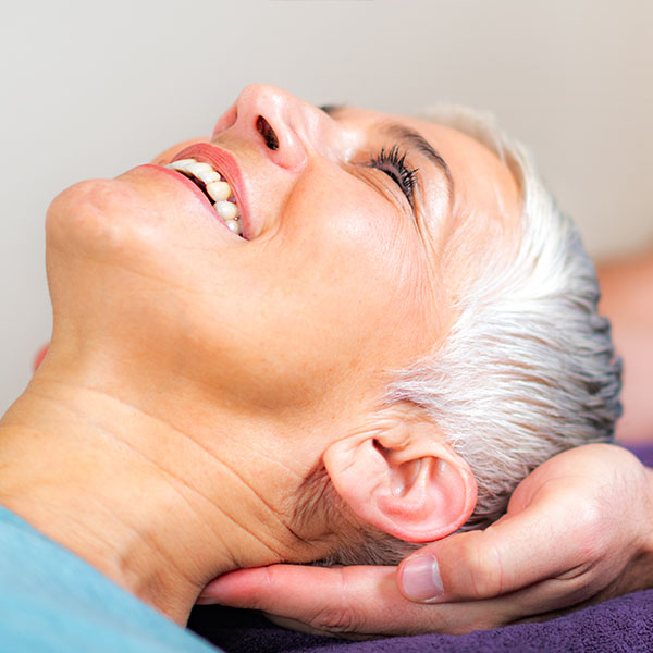 physiotherapeutische Nackenmassage bei einer älteren Dame